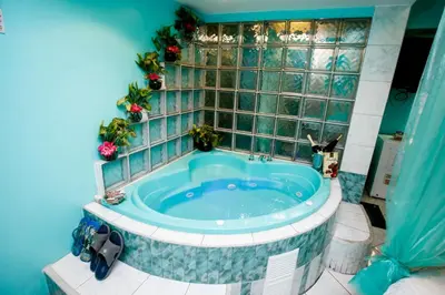 a bathroom with a jacuzzi tub with a tile wall at Hospedaje El Remanso in Lima