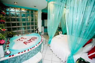 a room with a bed and a tub with red candles at Hospedaje El Remanso in Lima
