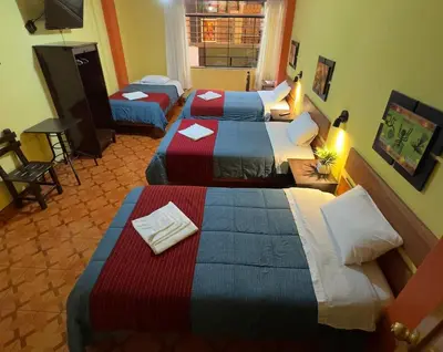 a hotel room with three beds in a room at Hospedaje San Francisco in Machu Picchu