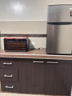 a kitchen counter with a refrigerator and a microwave at Apartamento Quillque House in Cusco