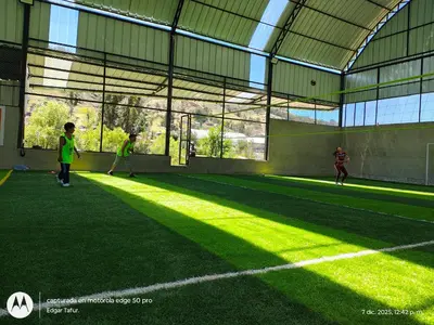 a group of people playing soccer on an indoor field at Nuevo campo verde eirl in Lima