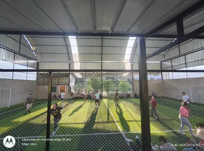 a group of people playing baseball in a batting cage at Nuevo campo verde eirl in Lima
