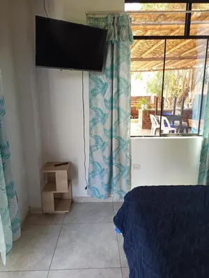 a bedroom with a bed and a window with a television at Casa rústica in Ica