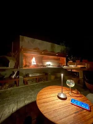 a wooden table with a wine glass and a fireplace at Country House in Azpitia Villa las Leñas in Santa Cruz de Flores