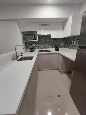 a white kitchen with a sink and a stove at Modern Apartment with AC and Pool near Miraflores, Fast WiFi in Lima