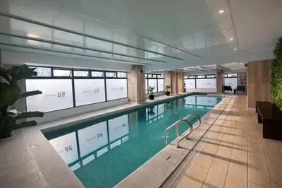 a large swimming pool in a building with windows at Modern Apartment with AC and Pool near Miraflores, Fast WiFi in Lima