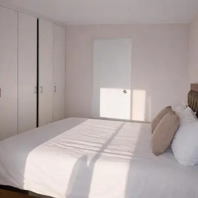 a white bedroom with a large bed with white cabinets at Modern Apartment with AC and Pool near Miraflores, Fast WiFi in Lima