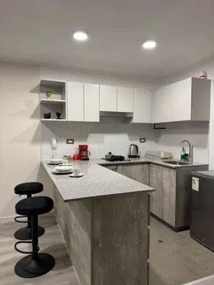 a kitchen with white cabinets and a counter top at Amalfi Apartment 612 Malecón de la Avenida Costanera in Lima