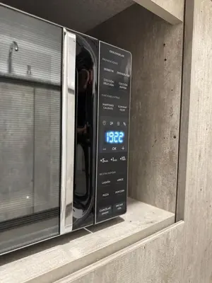 a microwave oven with a clock on a window at Amalfi Apartment 612 Malecón de la Avenida Costanera in Lima