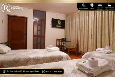 a hotel room with two beds with towels on them at Hotel Rogger in Huancayo