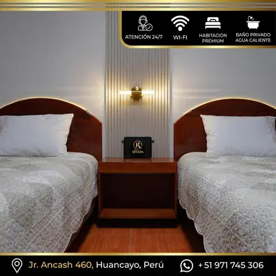 a room with two beds and a nightstand between them at Hotel Rogger in Huancayo