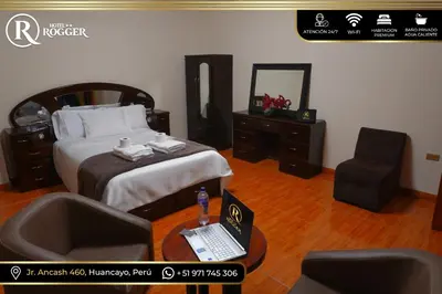a bedroom with a bed and a laptop on a table at Hotel Rogger in Huancayo