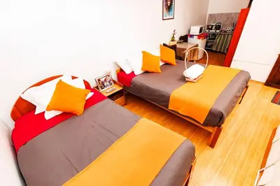 two beds in a room with two bedsskirts at Mayu House Inn I a minutos de la plaza in Cusco