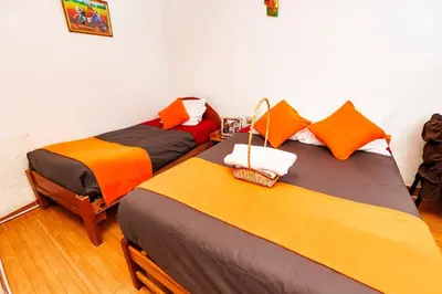 two beds sitting next to each other in a room at Mayu House Inn I a minutos de la plaza in Cusco