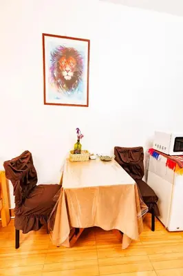 a table with two chairs and a painting of a lion at Mayu House Inn I a minutos de la plaza in Cusco
