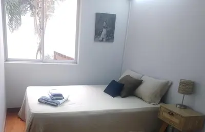 a bedroom with a white bed with a window at Coliving Barranco in Lima
