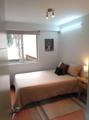 a bedroom with a large bed with a window at Coliving Barranco in Lima