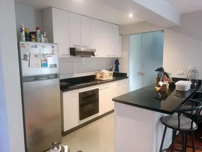 a kitchen with a refrigerator and a black counter top at Coliving Barranco in Lima
