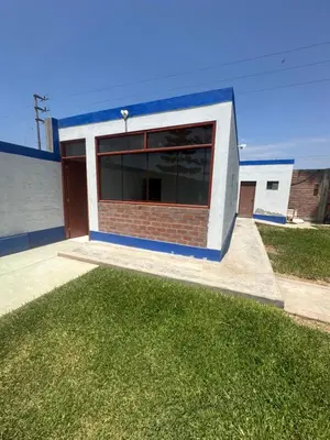 a building with a large window and a grass yard at Casita de Campo y Relax con Piscina in Cerro Azul