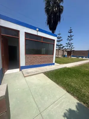 a blue and white building with a garage at Casita de Campo y Relax con Piscina in Cerro Azul