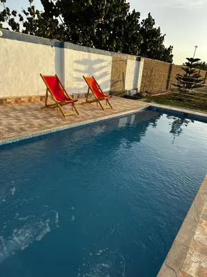 two red chairs sitting next to a swimming pool at Casita de Campo y Relax con Piscina in Cerro Azul