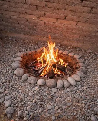 a fire burns in a circle of rocks at Casita de Campo y Relax con Piscina in Cerro Azul