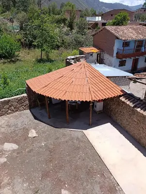an orange roofed picnic table in front of a building at Hostal Ayllu con cochera in Urubamba