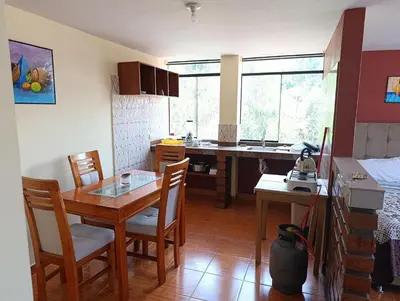 a kitchen with a table and chairs in a room at Hostal Ayllu con cochera in Urubamba