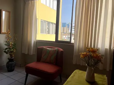 a living room with a chair and a window at Confortable and central in Lima