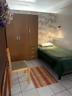 a bedroom with a bed and a chair and a cabinet at Confortable and central in Lima