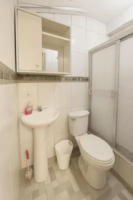 a white bathroom with a toilet and a sink at Habitación en Miraflores completa in Lima