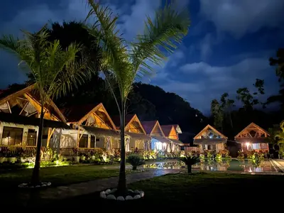 a resort at night with palm trees and lights at Hotel Tulumayo Lodge in San Ramón