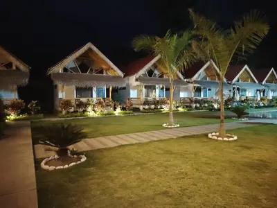 a home at night with palm trees in the yard at Hotel Tulumayo Lodge in San Ramón