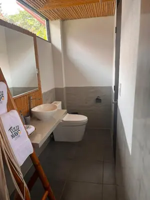 a bathroom with a toilet and a sink at Hotel Tulumayo Lodge in San Ramón