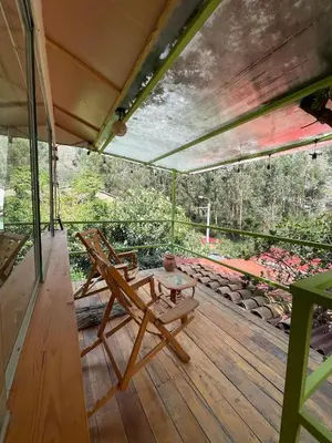 a deck with two chairs and a table on it at Casa llegada del Sol in Ollantaytambo