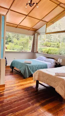 a bedroom with two beds and a large window at Casa llegada del Sol in Ollantaytambo