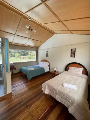 a bedroom with two beds and a large window at Casa llegada del Sol in Ollantaytambo