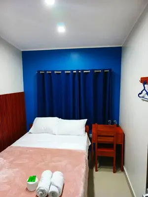 a bedroom with a bed and a blue wall at Alojamiento Oslo San Ramón in San Ramón