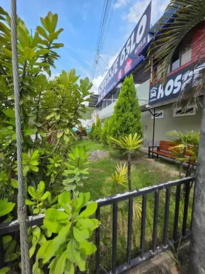 a garden in front of a building with a fence at Alojamiento Oslo San Ramón in San Ramón