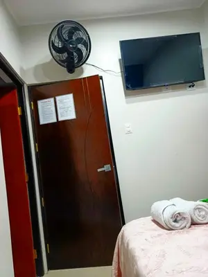 a room with a bed and a tv on the wall at Alojamiento Oslo San Ramón in San Ramón