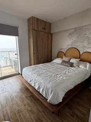 a bedroom with a large bed with a wooden headboard at Departamento en Punta Hermosa frente al mar in Punta Hermosa