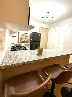 a kitchen with a stove and a counter with stools at Brand New Apartment in Lima