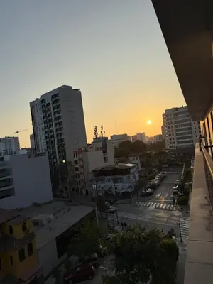 a view of a city with the sun setting behind buildings at Brand New Apartment in Lima