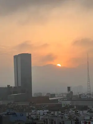 a city skyline with the sun setting in the background at Departamento céntrico a San Isidro San Borja in Lima