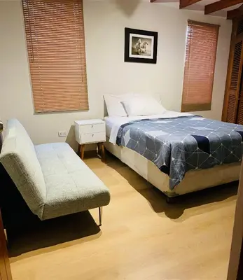 a bedroom with a bed and a chair at Mini Depa Luminoso con Cocina, a Pasos del Parque Kennedy Miraflores in Lima