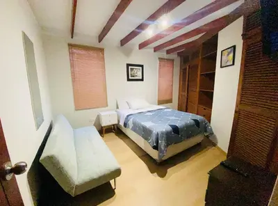a bedroom with a bed and a couch at Mini Depa Luminoso con Cocina, a Pasos del Parque Kennedy Miraflores in Lima