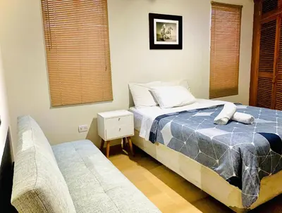 a bedroom with a bed and a couch at Mini Depa Luminoso con Cocina, a Pasos del Parque Kennedy Miraflores in Lima