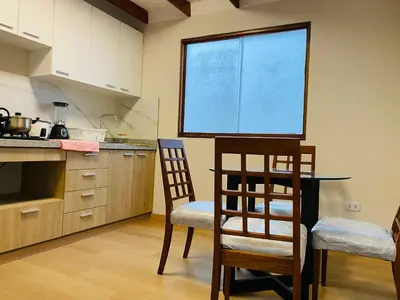a kitchen with a table and two chairs and a window at Mini Depa Luminoso con Cocina, a Pasos del Parque Kennedy Miraflores in Lima