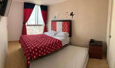a bedroom with a red and white bed with a window at Departamento 03 dormitorios cerca Arena 1 in Lima