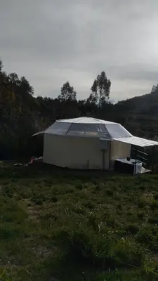 a small building with a roof in a field at Cusco Sana Lodge in Cusco